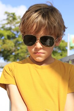 Cool blond boy wearing sunglasses