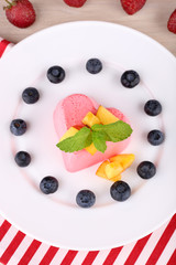 Heart shaped cake with fruits and berries on plate on napkin