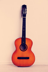 Guitar on the floor on beige background