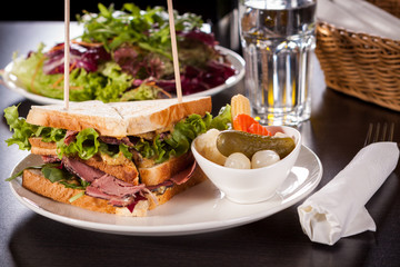 Delicious pastrami club sandwich and pickles