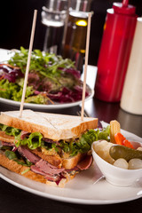 Delicious pastrami club sandwich and pickles