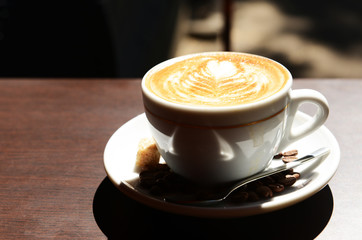 Cup of coffee with cute drawing in cafe