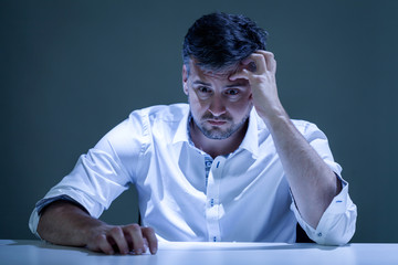 Worried young man sitiing at the table