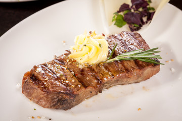 Grilled beef steak topped with butter and rosemary