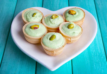 Tartlets with greens and sauce on plate on table