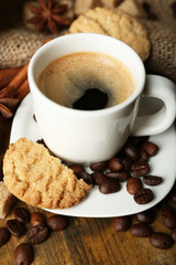 Cup of espresso and tasty cookie on wooden background