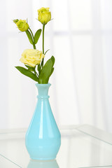 Beautiful bouquet of flowers in vase on window background