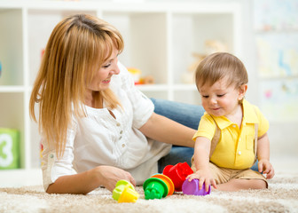 little child and woman playing with toys