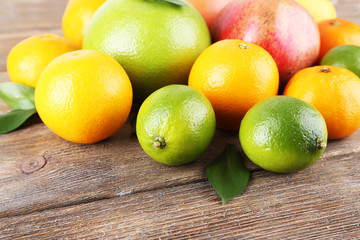 Ripe citrus with green leaves on wooden background