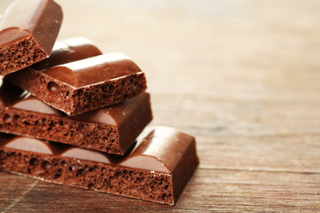 Tasty porous chocolate on wooden table
