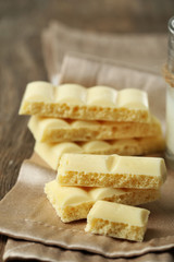 Tasty white porous chocolate on wooden table, close up