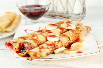 Plate of delicious pancakes with berry jam on wooden background
