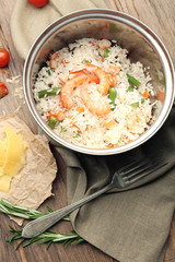 Tasty rice in pan on wooden table