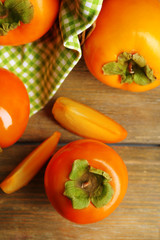 Ripe persimmons on wooden background