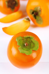 Ripe persimmons on color wooden background