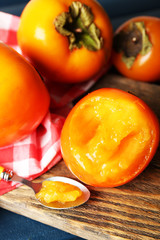 Ripe persimmons on cutting board,   close-up
