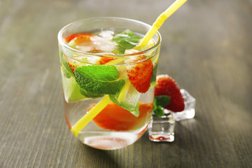 Summer cocktail with ice cubes on wooden table