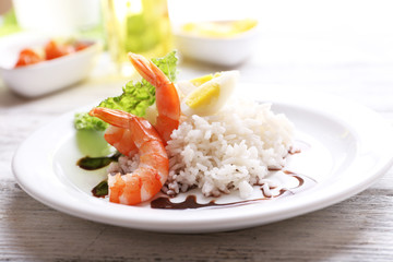 Boiled rice with shrimps served on table, close-up
