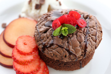 Hot chocolate pudding with ice-cream and fruits, close-up