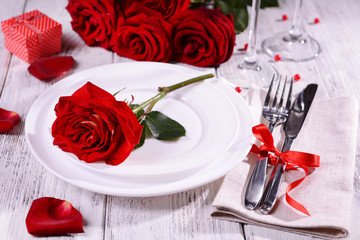 Fototapeta na wymiar Beautiful romantic table setting with red roses close-up