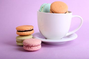 Obraz na płótnie Canvas Assortment of gentle colorful macaroons in colorful mug