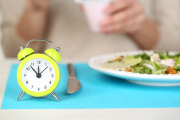 Alarm clock and dietary food on table close-up