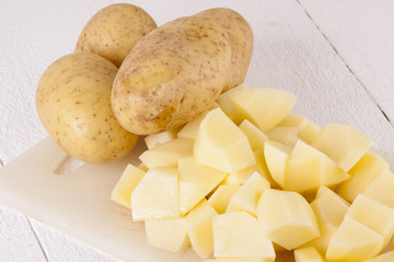 Whole Potatoes and Chopped Pieces on Cutting Board