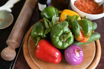 Ingredients for pizza on a wooden board.