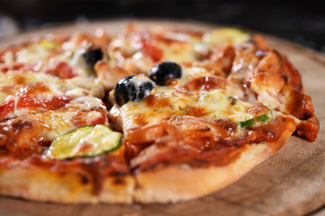 close up of pizza on wooden board.