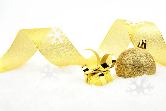 Golden christmas gift,bauble with golden ribbon on snow