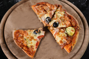 close up of pizza on wooden board.