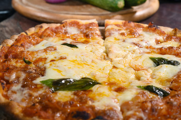 close up of pizza on wooden board.