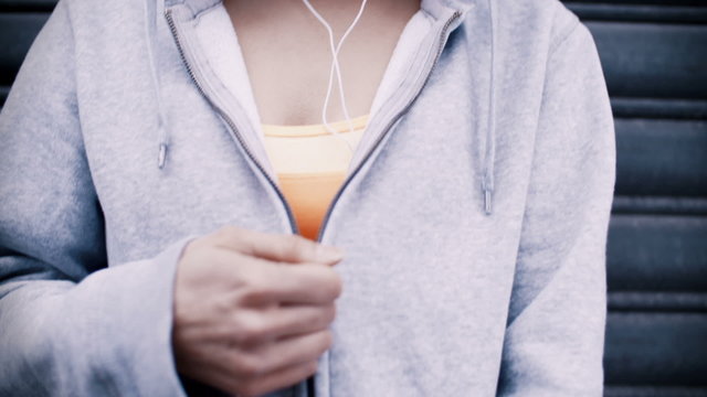 Fitness Woman closing zipper over sports bra