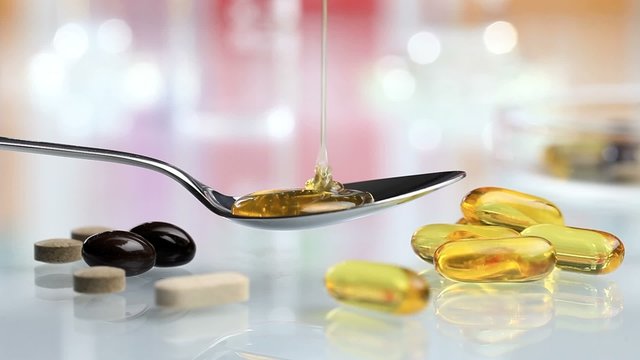 syrup poured into spoon with vitamins and supplements