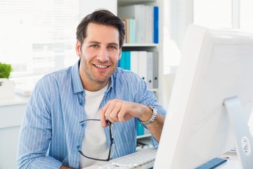 Editor working at his computer while looking at camera