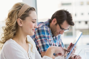 Smiling casual blonde using tablet