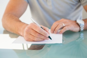 Mid section of a writing notes on paper