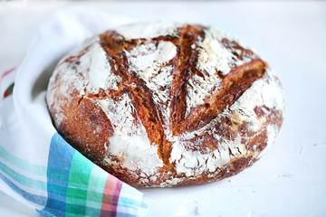Rye artisan bread dusted with flour on a napkin, sourdough