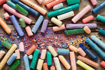 Collection of rainbow colored pastel crayons with pigment dust o