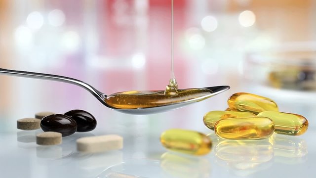syrup poured into spoon with vitamins and supplements