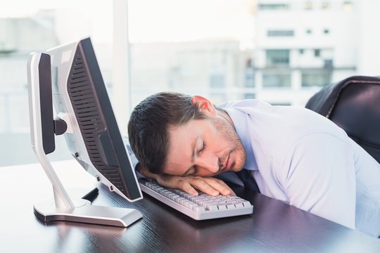 Exhausted businessman sleeping at his desk