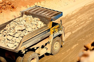 huge trucks work in a quarry mining