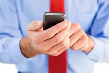 Businessman texting on his mobile phone
