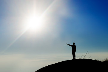 Silhouette of a champion on mountain top pointing