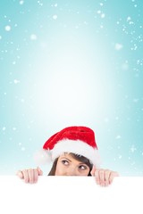 Festive brunette holding a poster while looking up