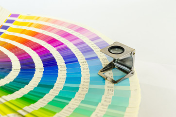 The magnifying glass standing on a color palette print