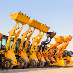 The row of heavy construction excavator machine  against blue sk