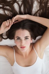 Fototapeta premium Pretty brunette posing on bed