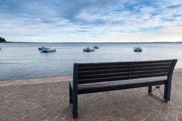 Fototapeta na wymiar Wood bench at the Garda lake