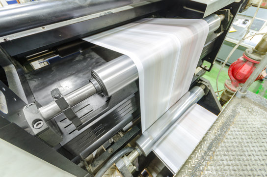 A large webset offset printing press running a long roll off paper